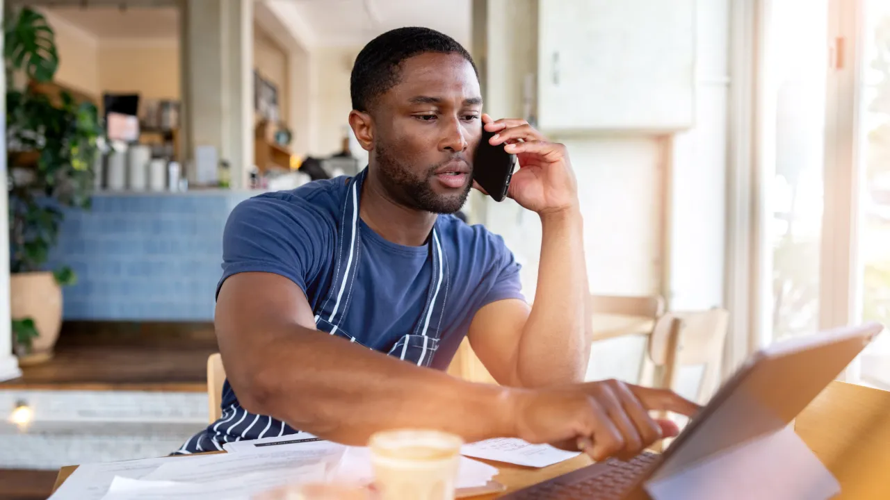 Businessman making a call on mobile while interacting with a tablet