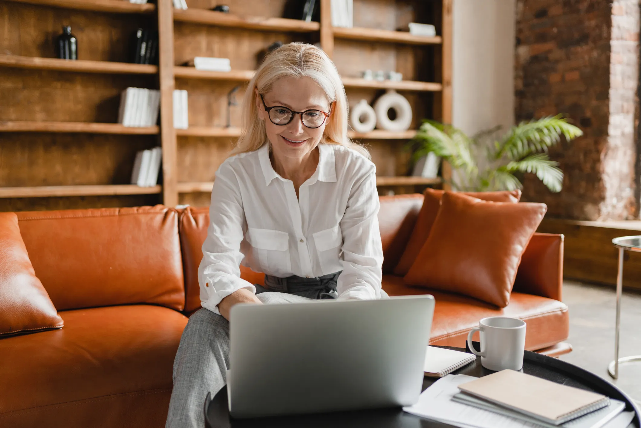 Woman working on a laptop in an office while sending a fax online