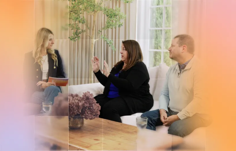 A group of professionals engaged in a discussion on a couch in a bright, modern setting.