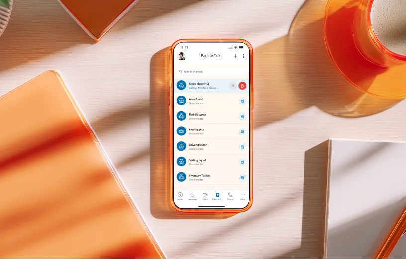 Smartphone displaying the RingCentral app's Push to Talk feature interface on a desk with orange accents.