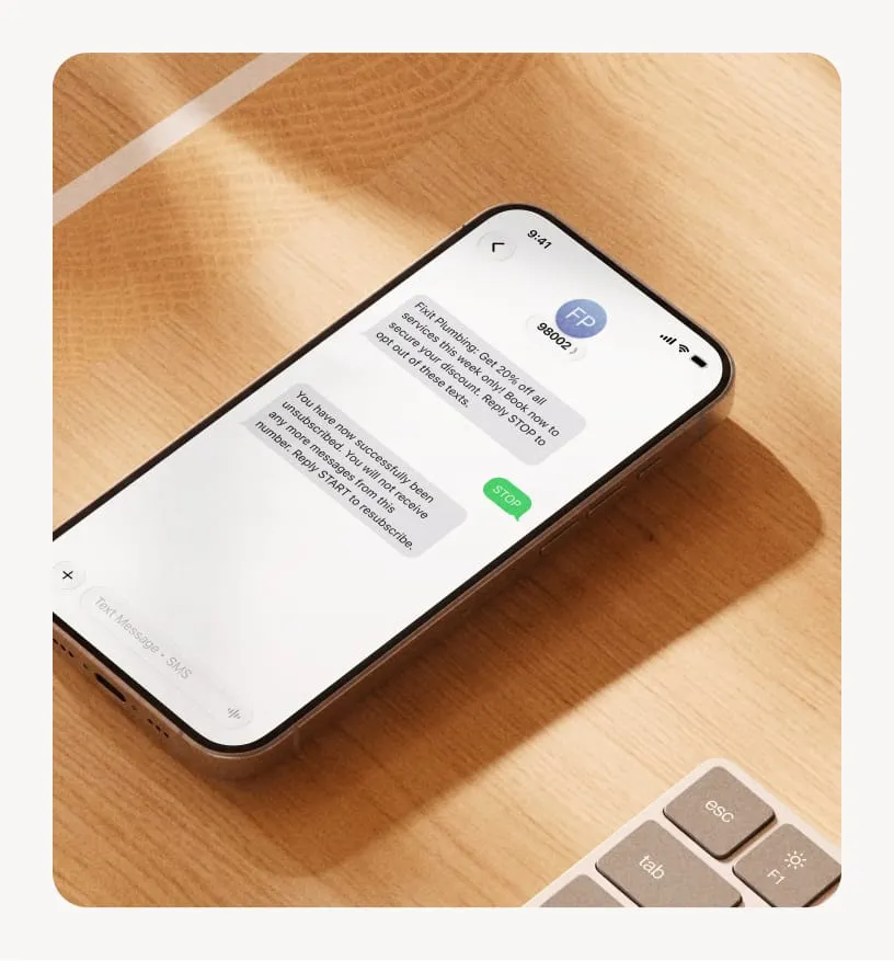 Mobile phone on a desk showing a text message conversation with options to unsubscribe or resubscribe to services.