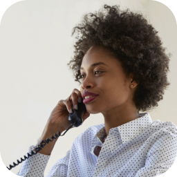 A side profile of a woman talking on a landline phone