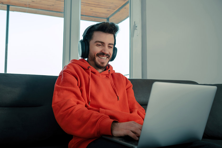 Homme en télétravail souriant devant son ordinateur