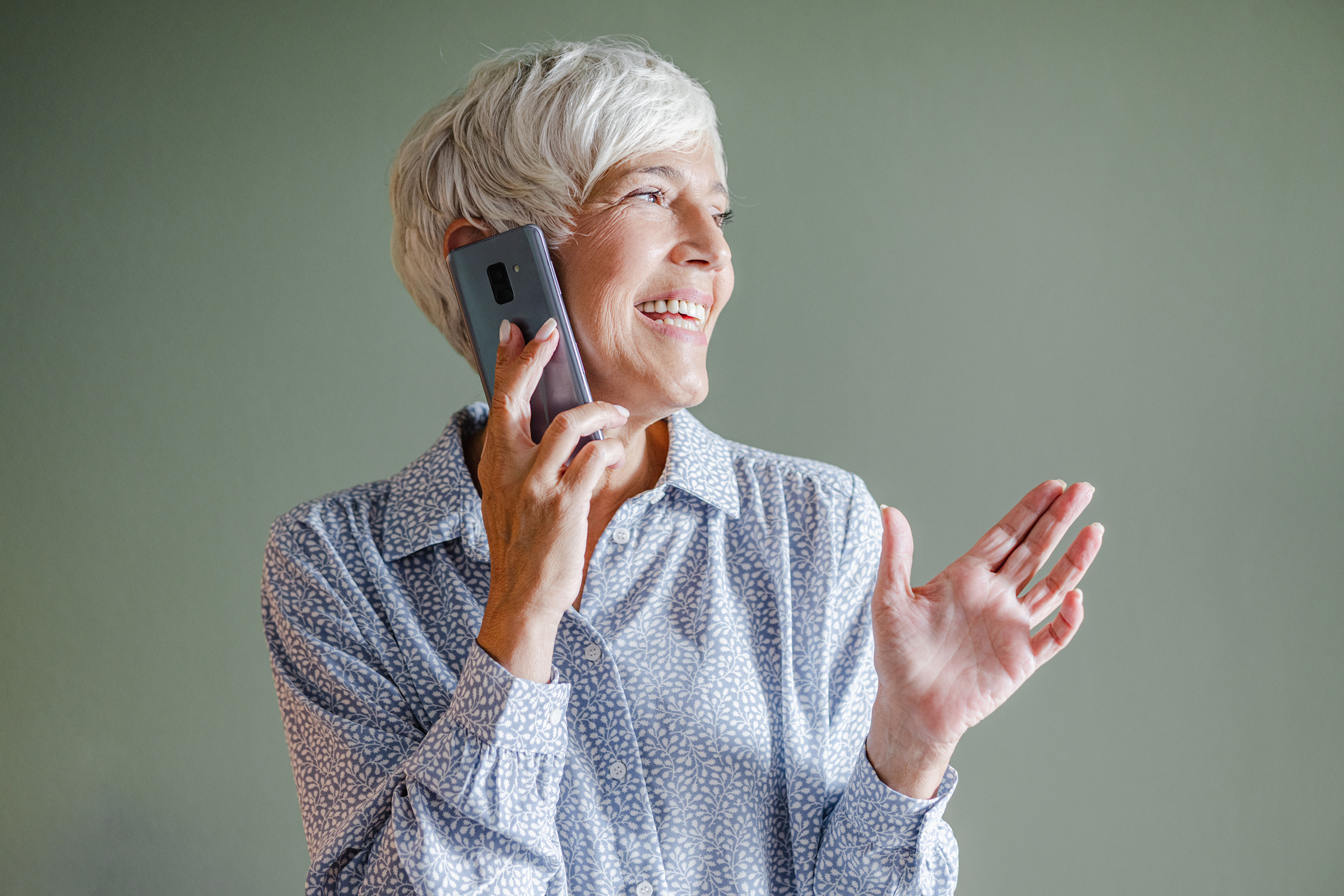 Une femme tenant un téléphone portable et écoutant la messagerie vocale