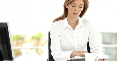 Female CFO sat at her desk in her office reading a report