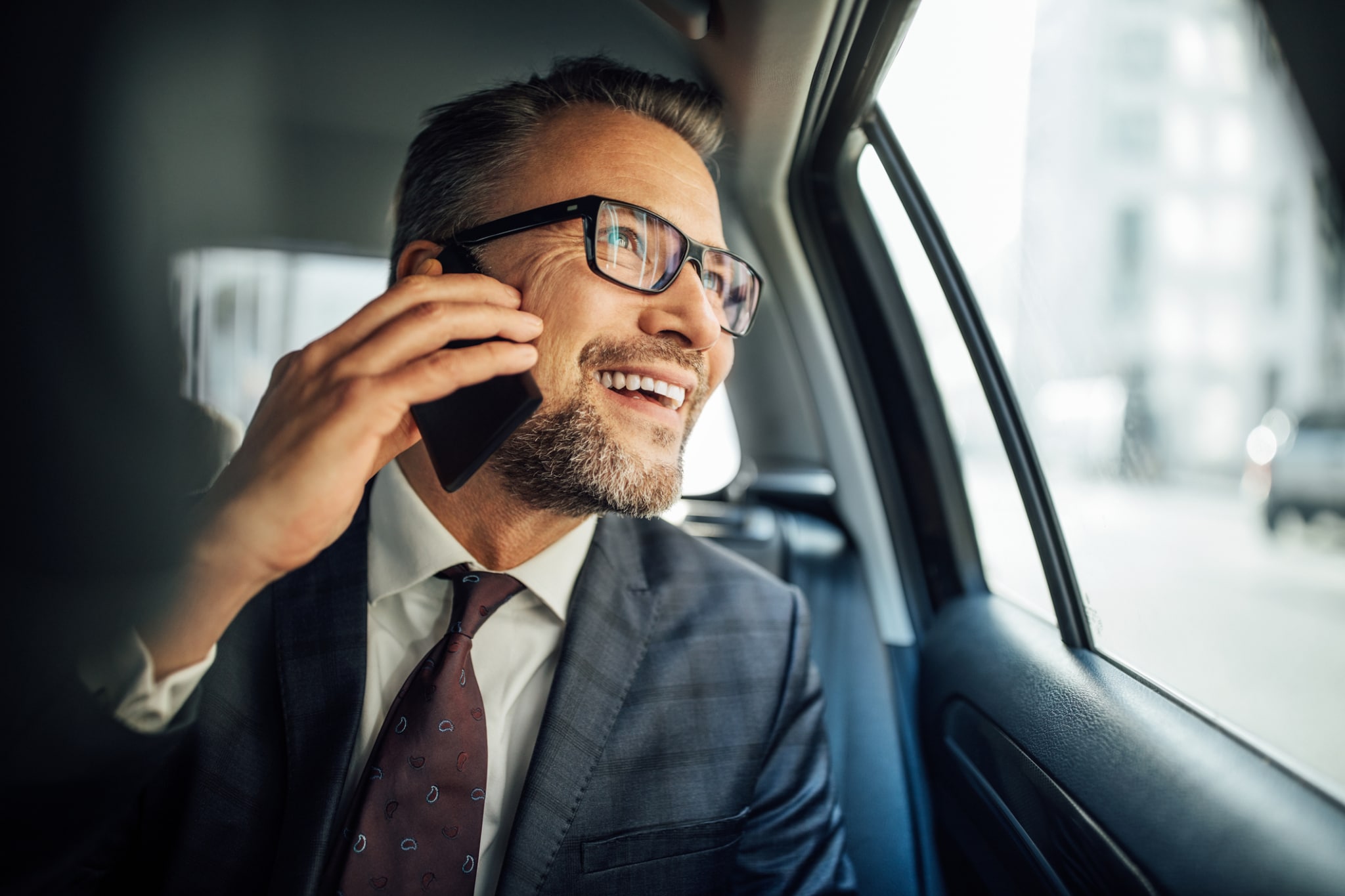 Entrepreneur using phone while traveling by a car-224