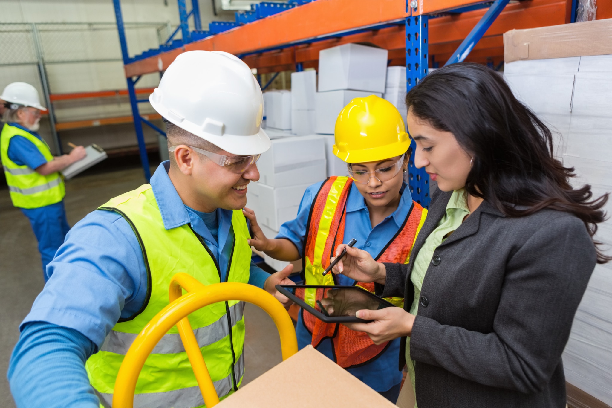 supervisor reveiwing purchase order with workers in warehouse
