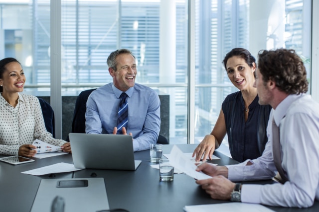 Businesspeople discussing at conference table - enterprise collaboration