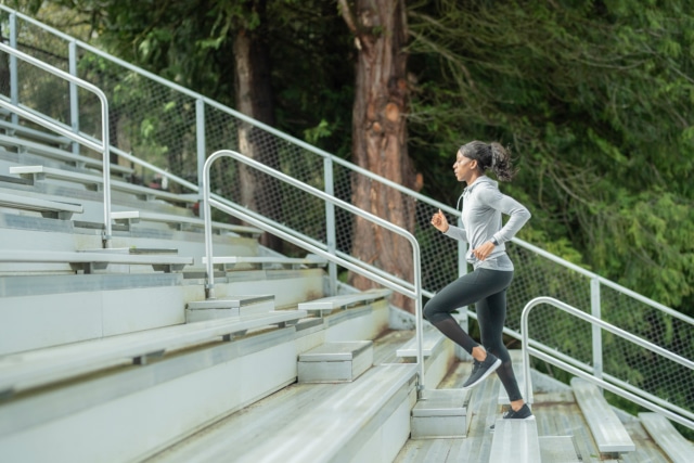 Female track athlete trains on stadium bleachers-644