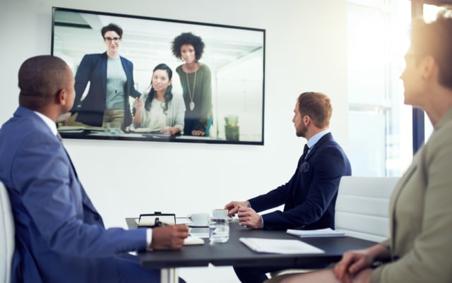 a diverse team of colleagues having a free conference call in a modern office