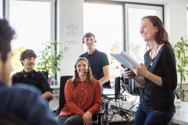 Smiling businesswoman discussing with colleagues in meeting-733