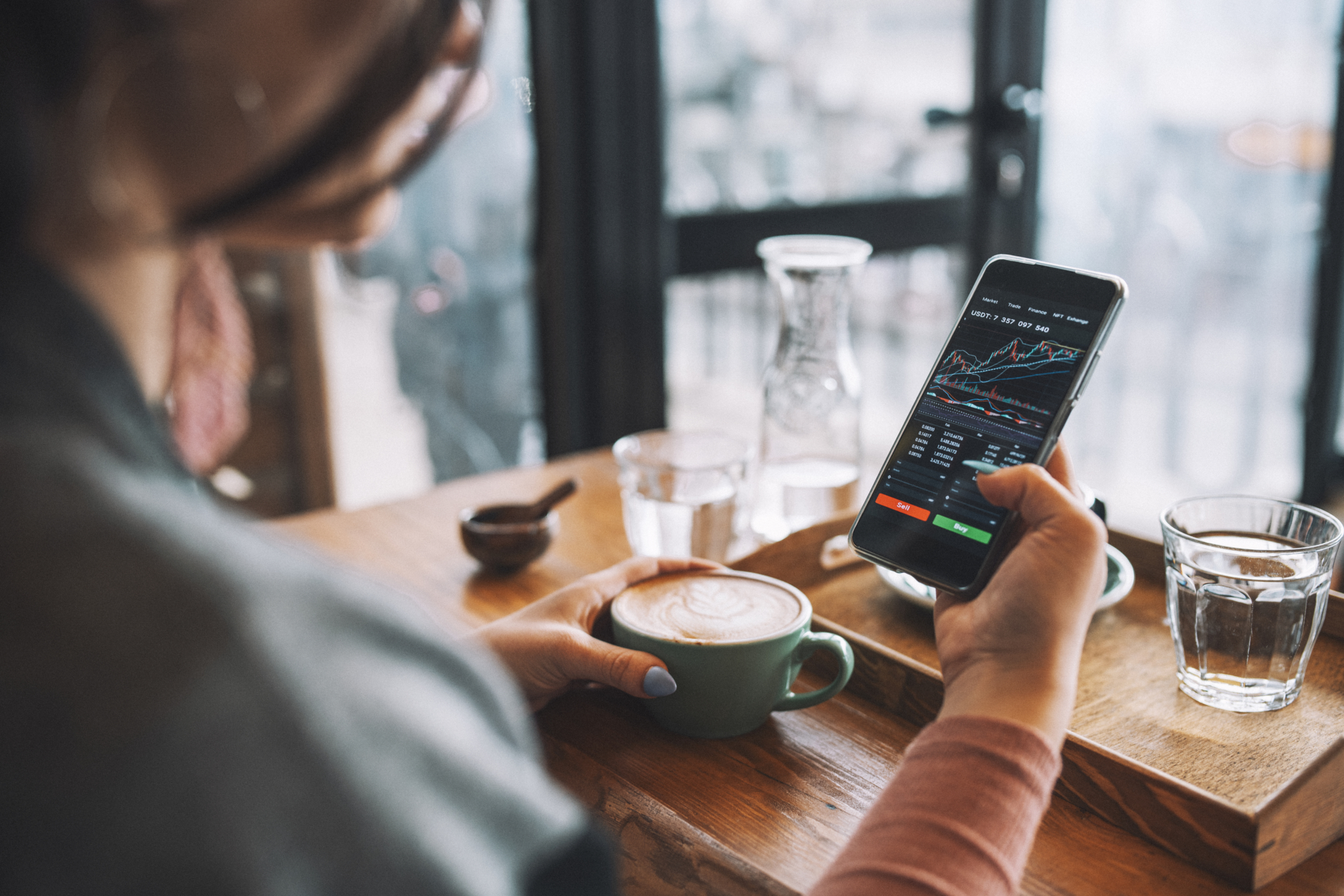 Woman using smartphone buy cryptocurrency at a coffee shop, blockchain investment, decentralize and Stock market concept.-509