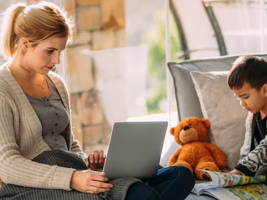 A woman works from home while parenting