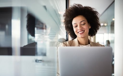 Smiling woman typing on a laptop