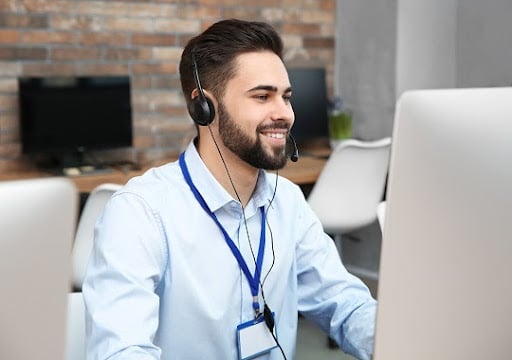 Technical support operator with headset working in office
