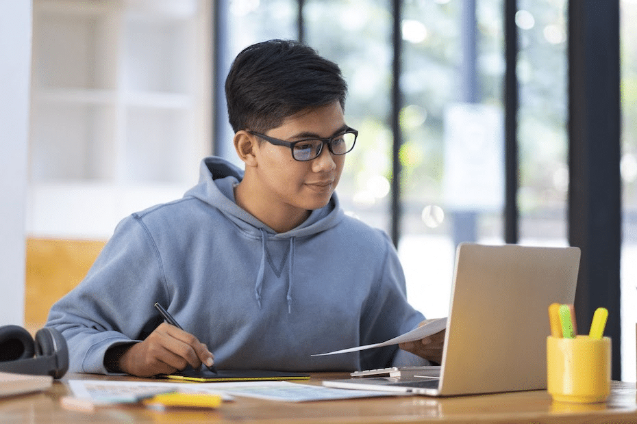 Male student with glasses learning via technology