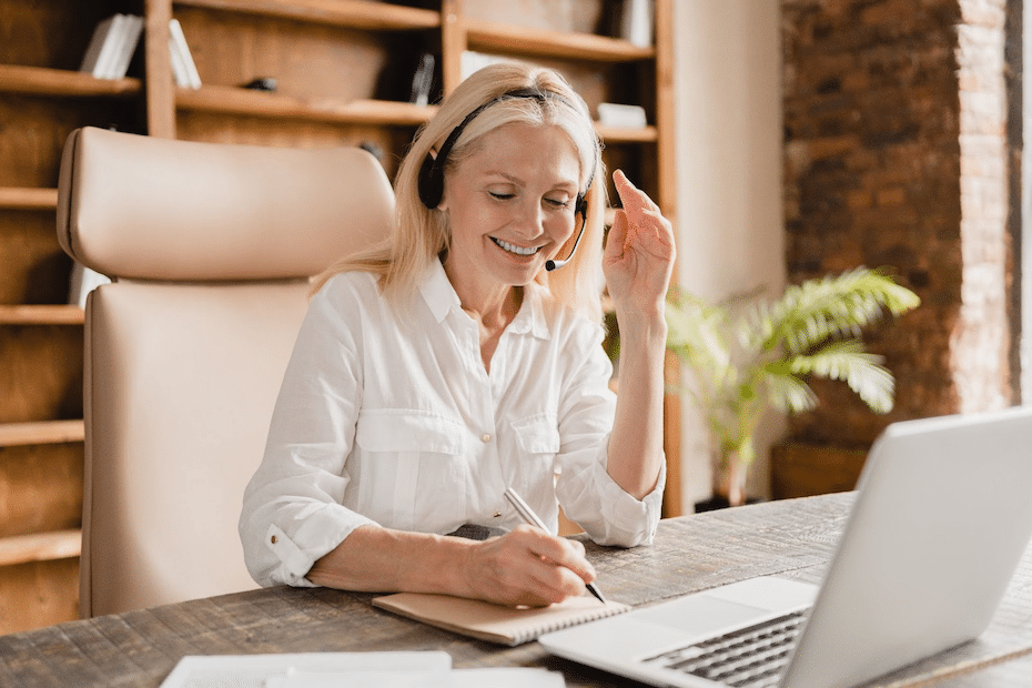 Woman with headset collaborates digitally while smiling