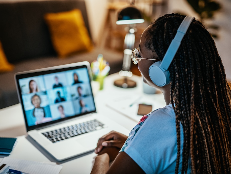 African American female student learning from home; attending online meeting with group of unrecognizable international students