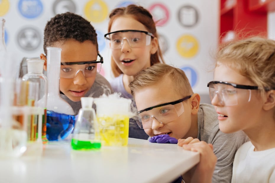 Young students wearing goggles and performing an experiment as part of brain-based learning techniques