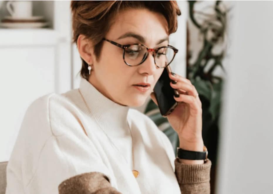 Financial advisor with a serious expression using a cloud-based communications platform to call a client on her mobile and give advice about the Great Resignation.