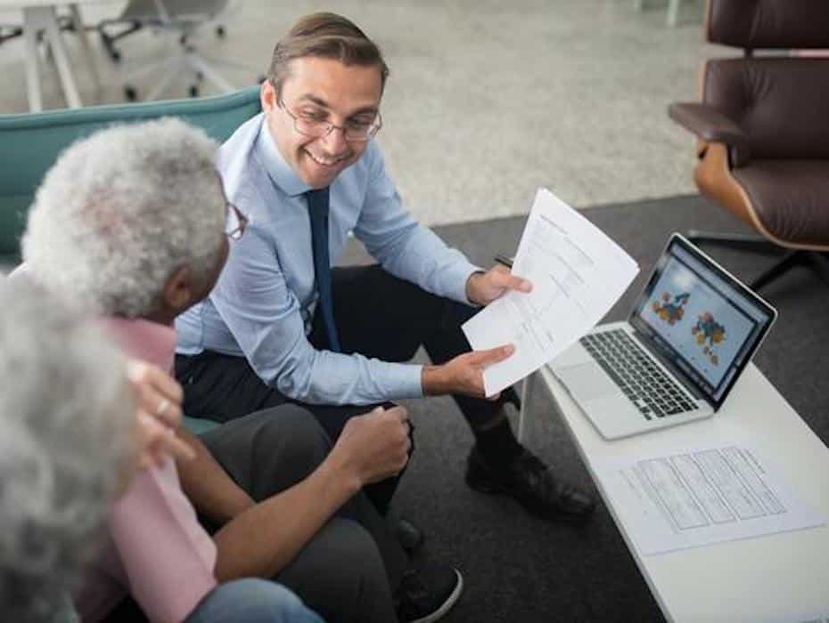 An insurance agent sitting at a table with clients