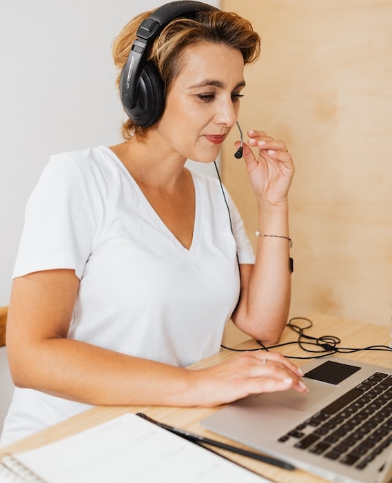 A financial services call center agent with a headset sits in front of a laptop