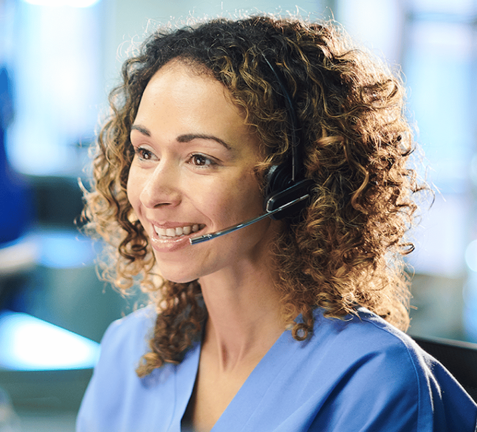 A smiling woman with a headset sits at her computer