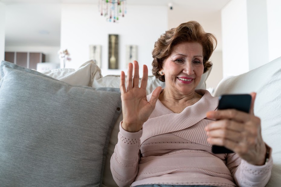 A long-term care resident engages with people via a mobile phone