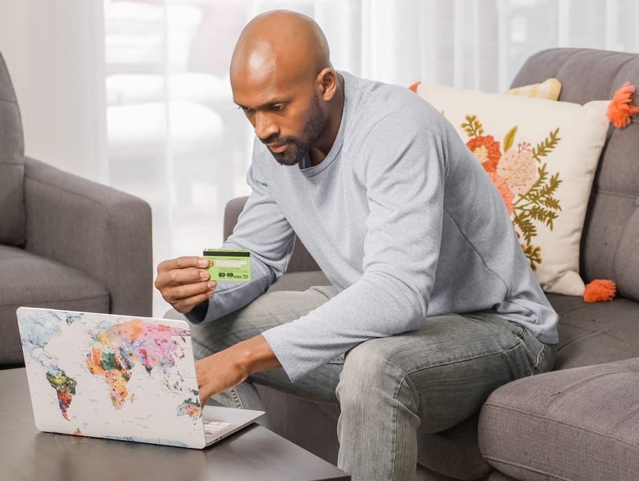 A financial services customer sitting in front of a laptop on his couch.