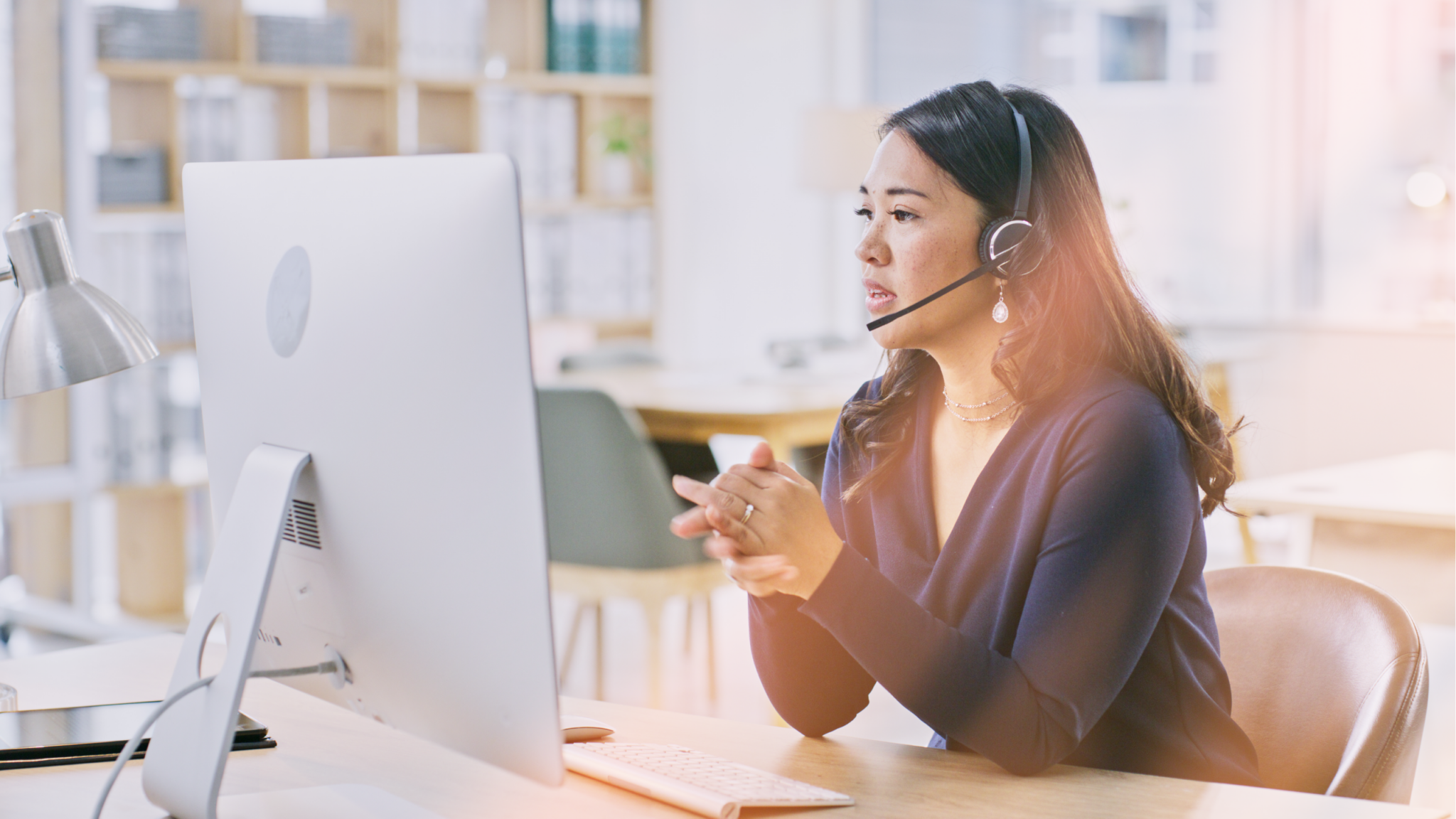 Contact center rep woman on computer helping customer on headset