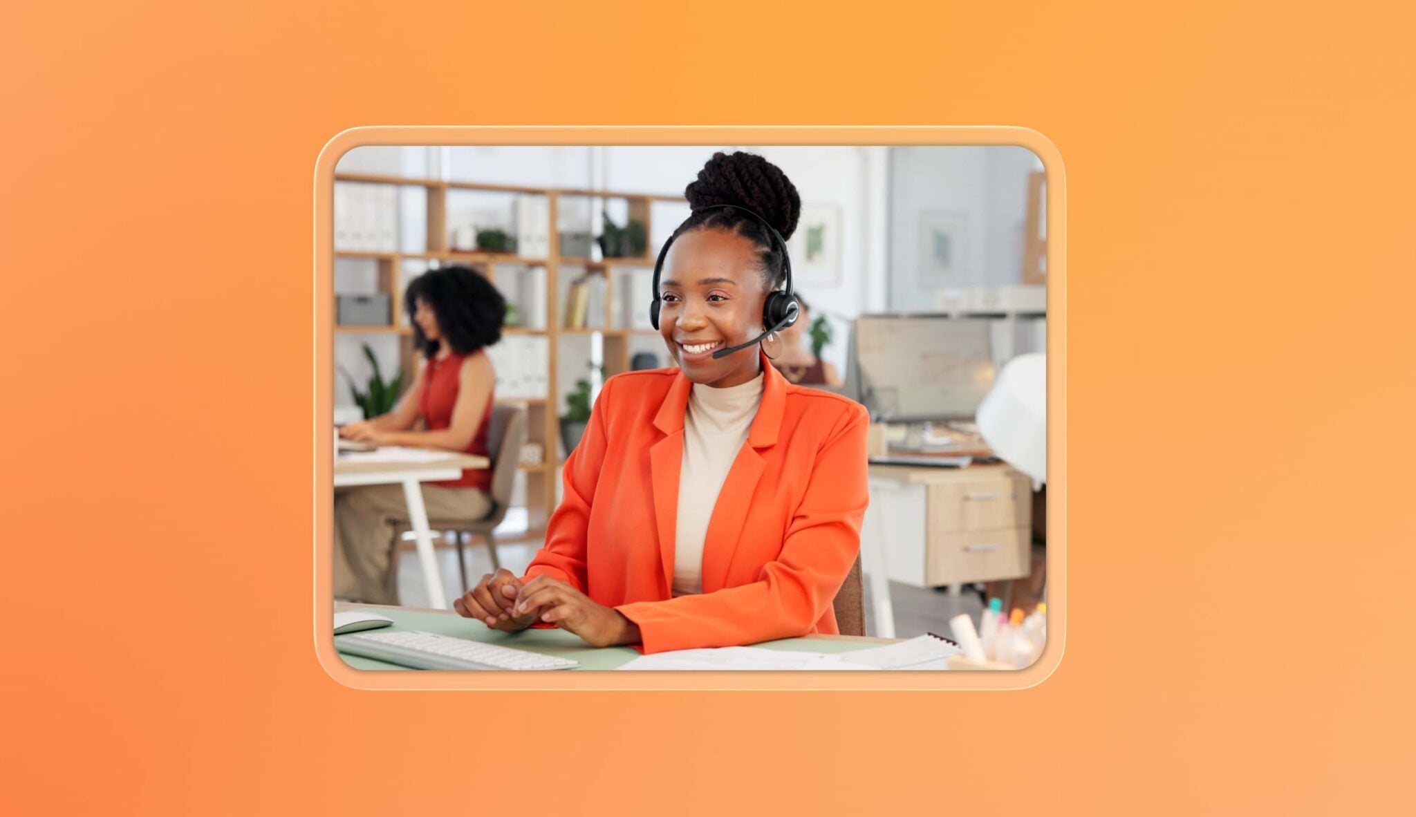 A contact center agent in an orange shirt is seated at a desk, using a headset to assist customers.
